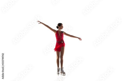 Girl figure skating isolated on white studio backgound with copyspace. Professional practicing and training in action and motion on ice. Graceful and weightless. Concept of movement, sport, beauty.