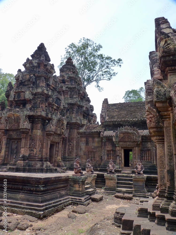 Naklejka premium Ruins of Angkor, temple of Banteay Srei, stone statue of guardians before pyramids, Angkor Wat, Cambodia