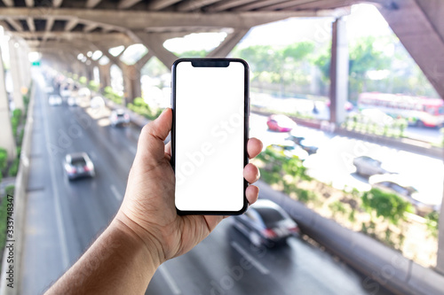 Asian man holding phone mock up center frame take photo car landind to fast at expressway isolated display for insert screen photo