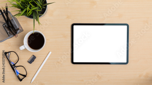 Wooden Table Office desk top view design workspace layout left have plant, coffee cup, pen, glasses, pencil and right space show mock up tablet isolated for insert on screen display