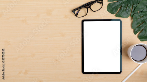 Wooden Table Office desk top view design workspace layout right have plant, coffee cup, pen, glasses near show mock up tablet isolated and empty left area for insert text or other