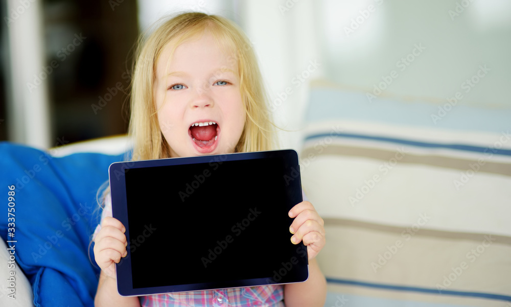Smart little schoolgirl with digital tablet in at home. Child using gadgets to study. Education and distance learning for kids. Homeschooling during quarantine. Smart little schoolgirl with digital tablet in at home. Child using gadgets to study. Education and distance learning for kids. Homeschooling during quarantine.
