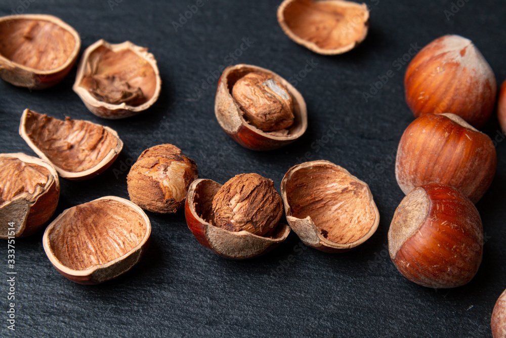 Shelled hazelnut with shell and kernel on a black background Shelled hazelnut with shell and kernel on a black background