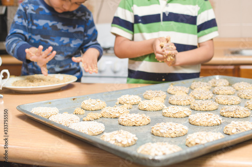 childrens hands making cookies on a wooden table