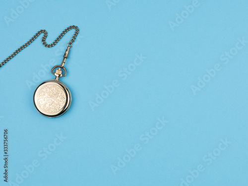 Pocket watch on a chain on a blue background.