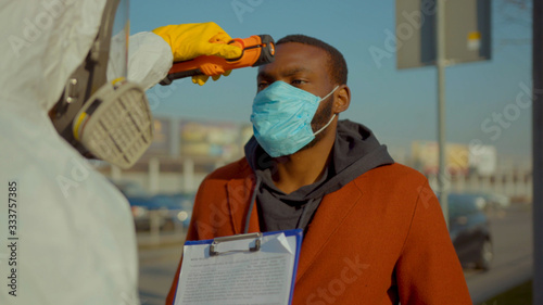 Near airport screening of passengers travellers african american man Covid-19 coronavirus symptoms temperature checkpoints mask infection epidemic corona passengers slow motion