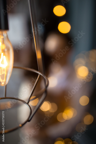 yellow lights bulbs and on the background in bokeh embraces a couple in love
