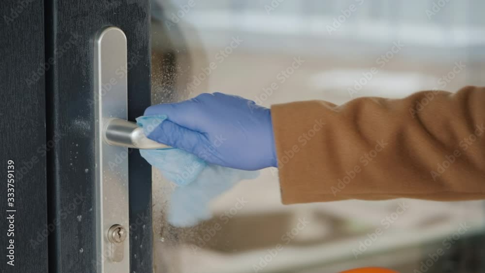 A hand in a protective glove on the handle of the front door. Protections in the midst of an epidemic A hand in a protective glove on the handle of the front door. Protections in the midst of an epidemic