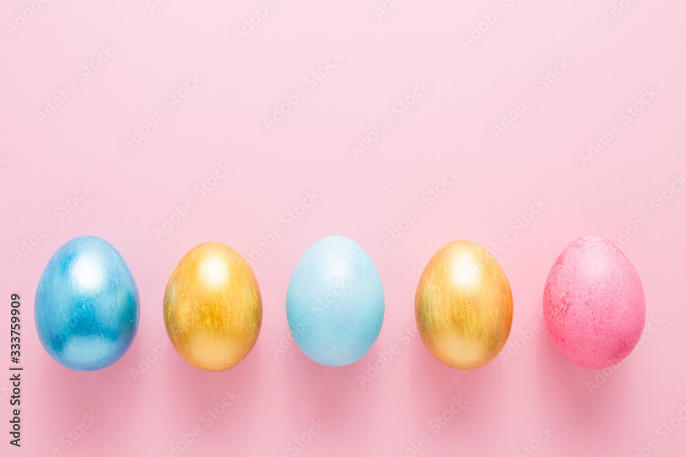 Multi-colored Easter eggs on a pink isolated background. Easter is a bright holiday.