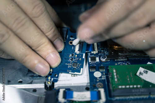 A close-up of an electrician repairing a computer circuit board,close up electrician hands are working with soldering iron