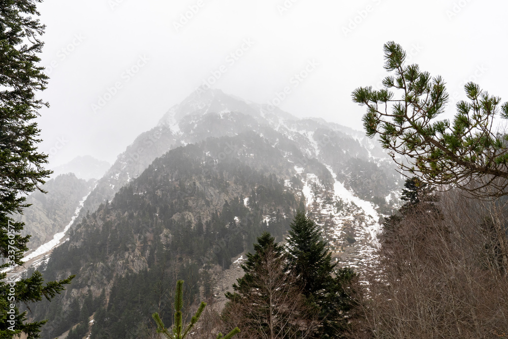 Mountain with fog and snow in National Park of Aigüestortes and lake of Sant Maurici.