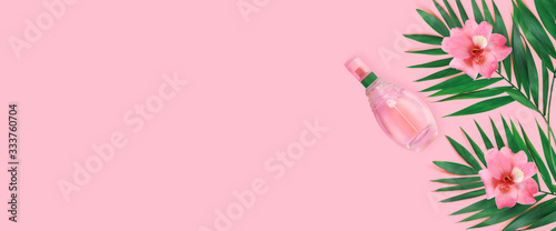 Minimal tropical green palm leaf with perfume and flowers in glass bottles  on  pink paper background. ..Flat lay Top view with copy space for  your text. © Loraliu