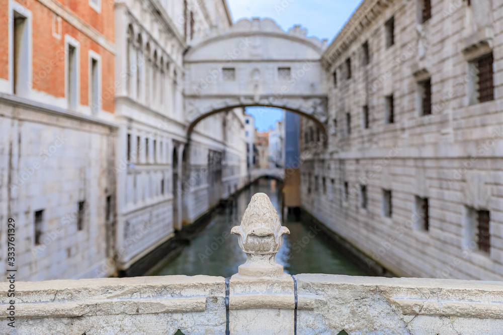 Carved pine cone on Ponte della Paglia with a view of Bridge of Sighs and the Doge's, Palace in Venice Italy at sunrise