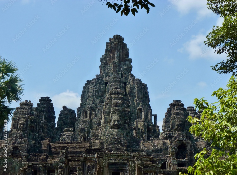 Ruins of Angkor, temple of Bayon with face towers, with trees, Angkor Wat, Cambodia