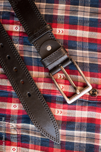 men's black leather trouser belt in the background, men's fashion accessories closet. Genuine leather, handmade belt