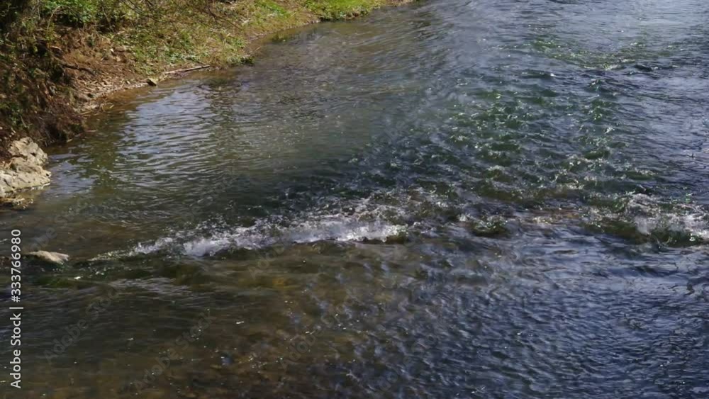 a stream of water flows along a river with stones a stream of water flows along a river with stones