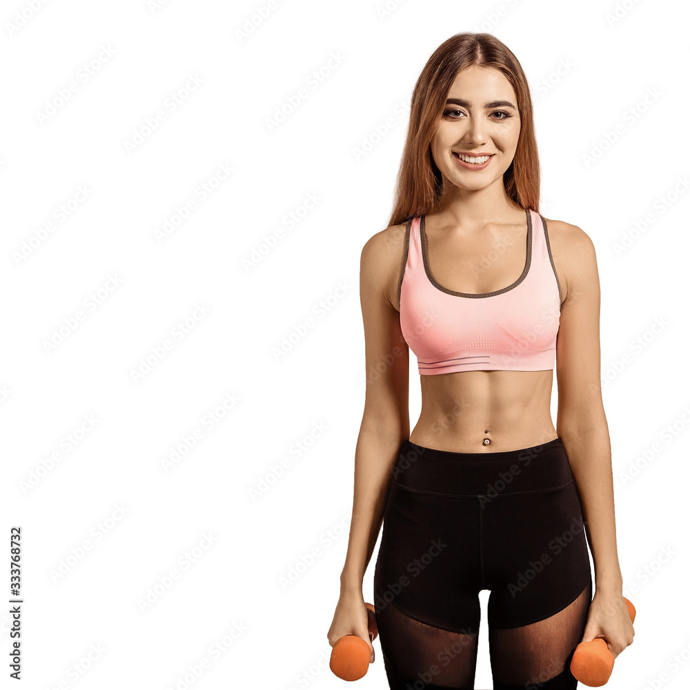 Beautiful, young woman standing in a sportswear, top and leggings. Tight, athletic body, thin, flat stomach. Holding dumbbells in his hands. Beautiful, young woman standing in a sportswear, top and leggings. Tight, athletic body, thin, flat stomach. Holding dumbbells in his hands.