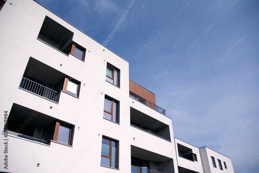 Exterior of new apartment buildings on a blue cloudy sky background. No people. Real estate business concept. Exterior of new apartment buildings on a blue cloudy sky background. No people. Real estate business concept.