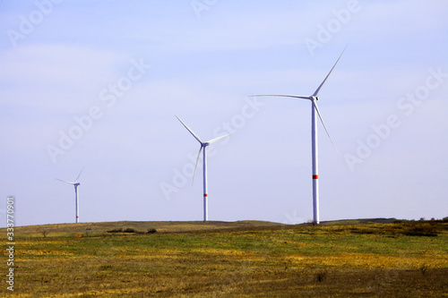 wind farm in a field against a blue sky