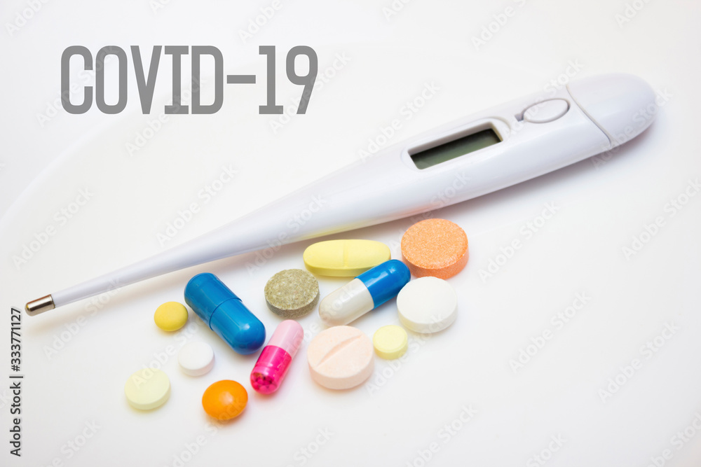 Electronic thermometer with tablets and capsules - quarantine, coronavirus, lettering covid19 Electronic thermometer with tablets and capsules - quarantine, coronavirus, lettering covid19