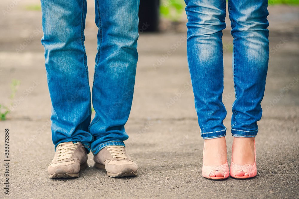 Legs of a guy and a girl in blue jeans Legs of a guy and a girl in blue jeans