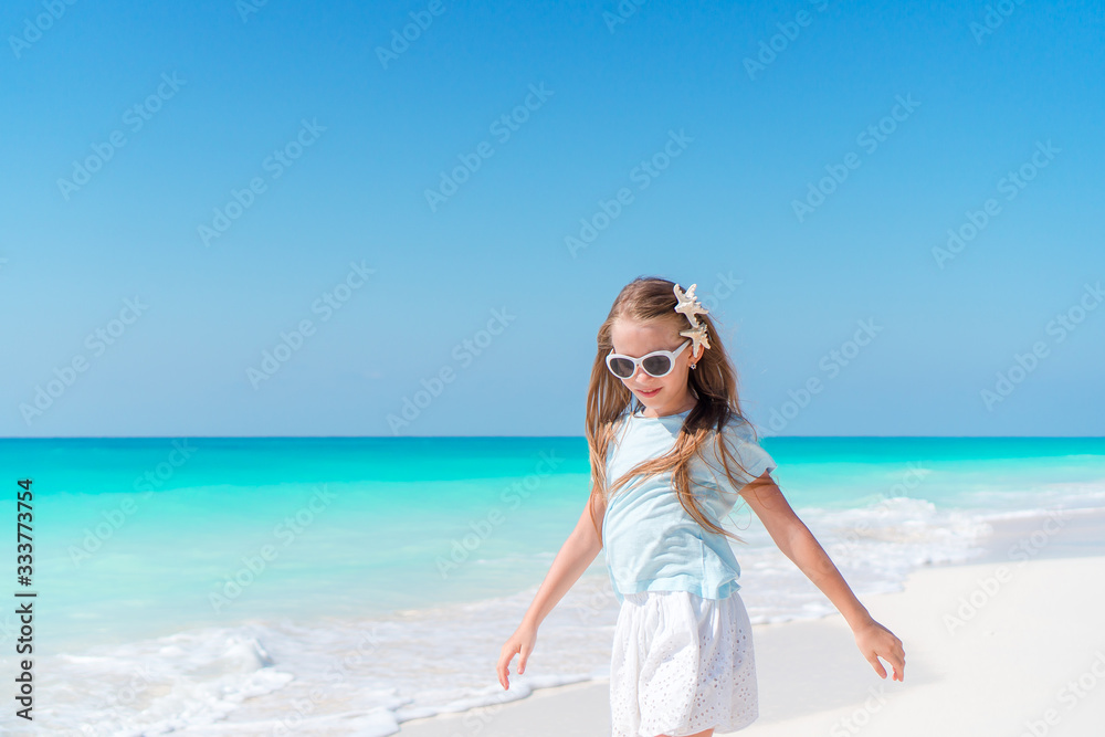 Adorable little girl have fun at tropical beach during vacation Adorable little girl have fun at tropical beach during vacation