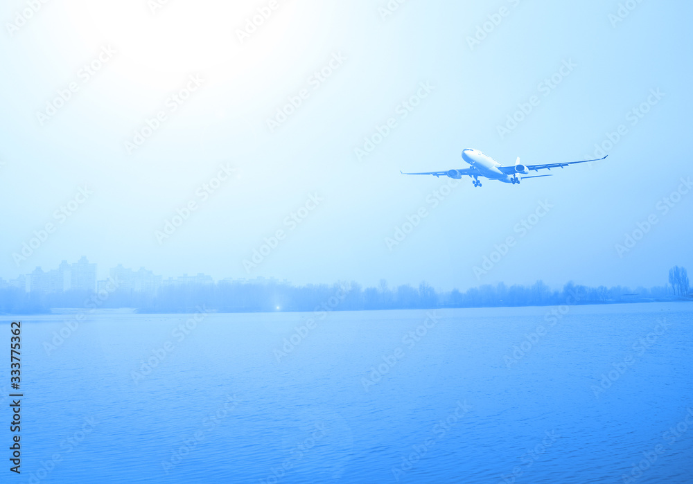 Naklejka premium Airliner over the lake and dark forest. Transport in nature