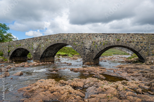 Mountain river and vintage bridge at Island of Skye, Hebrides archipelago, Scotland.
