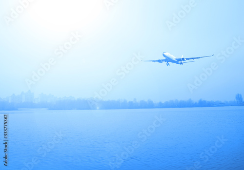 Airliner over the lake and dark forest. Transport in nature