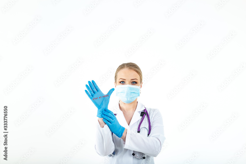 A young female doctor with protective latex gloves against coronavirus with a message to stay home. Stay at home