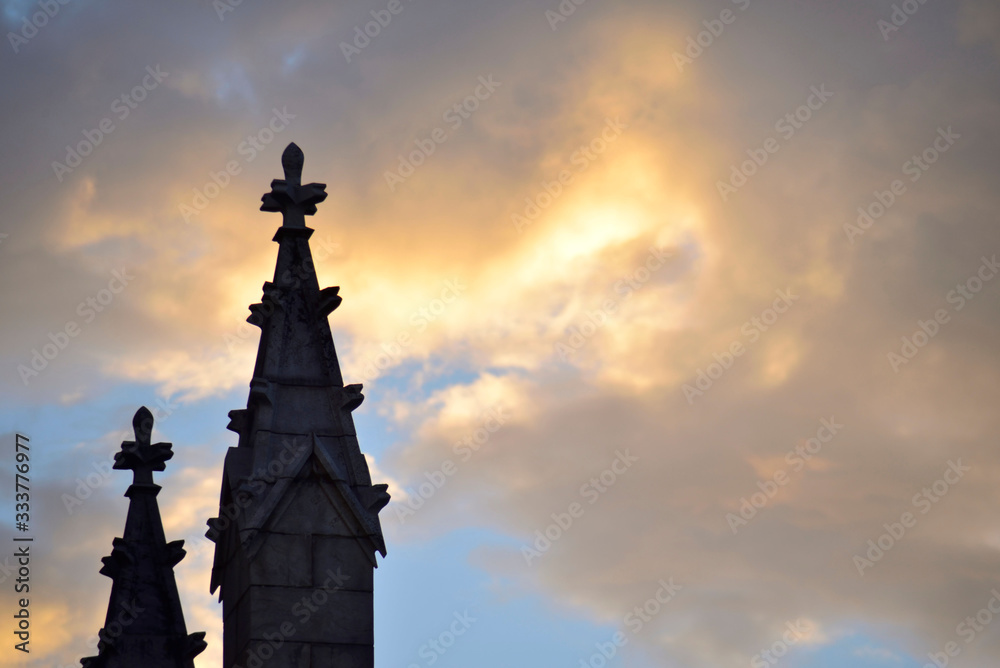 Silhouette of church pinnacles and sun between the clouds Silhouette of church pinnacles and sun between the clouds