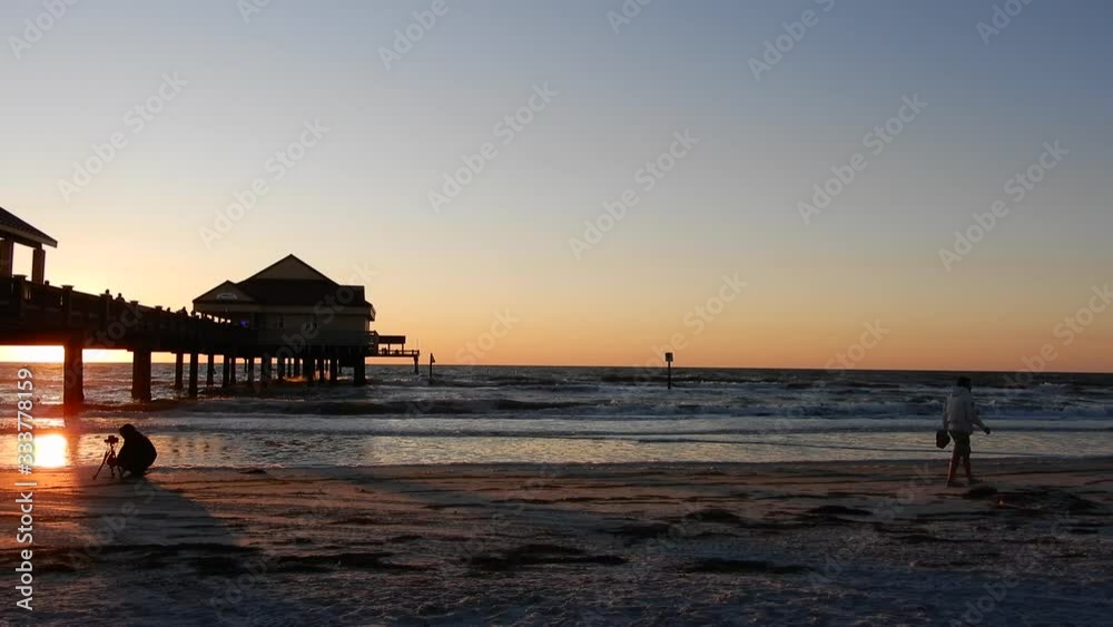 Left To Right Pan People Walking On Pier Bridge At Beach Resort To Photographer Capturing Golden Sunset 002 Left To Right Pan People Walking On Pier Bridge At Beach Resort To Photographer Capturing Golden Sunset 002