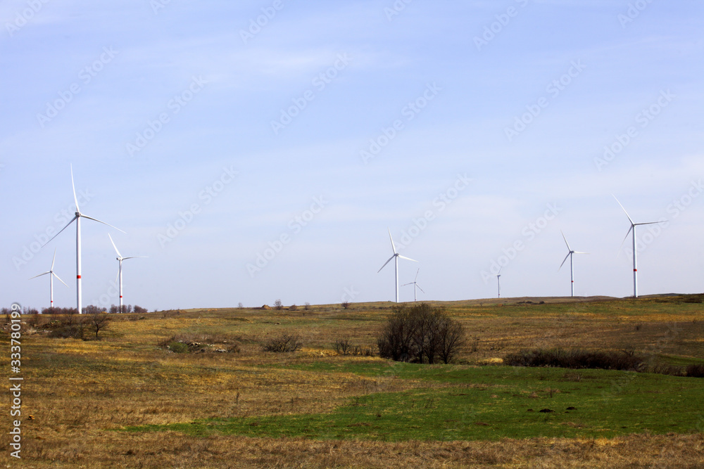 wind farm in a field against a blue sky wind farm in a field against a blue sky
