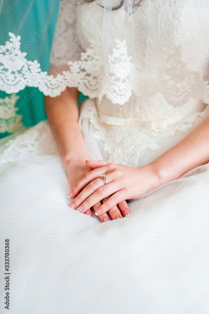 The bride folded her hands on her dress The bride folded her hands on her dress