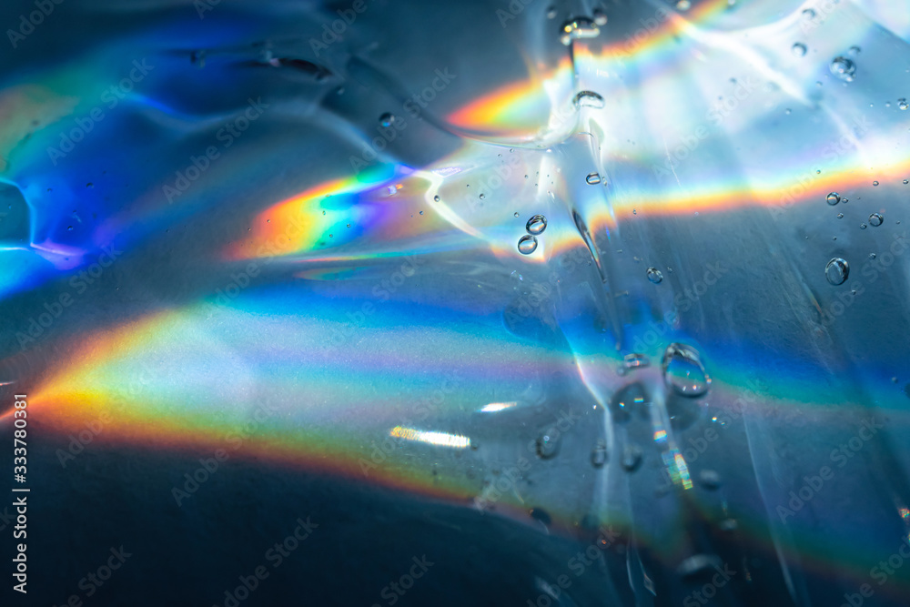 Transparent cosmetic antibacterial gel close-up in the rainbow light. The concept of cleanliness. Antiseptic.