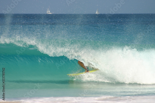 Surfer getting barreled on wave in azure clear Caribbean Sea