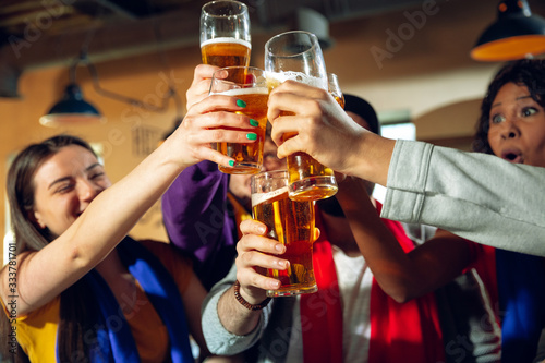 Photography Sport fans cheering at bar, pub and drinking beer while championship, competition is going