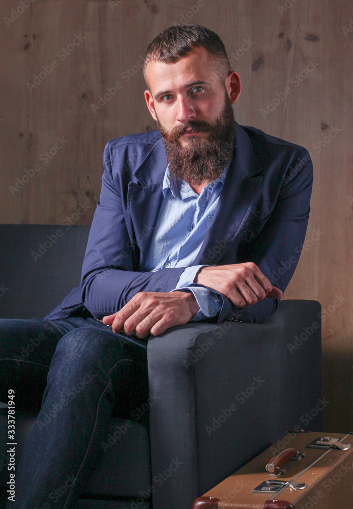Businessman sitting the sofa in office lobby, isolated on dark background Businessman sitting the sofa in office lobby, isolated on dark background