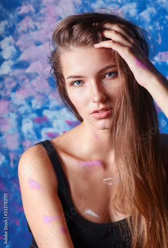 Young beautiful woman sitting near painting wall