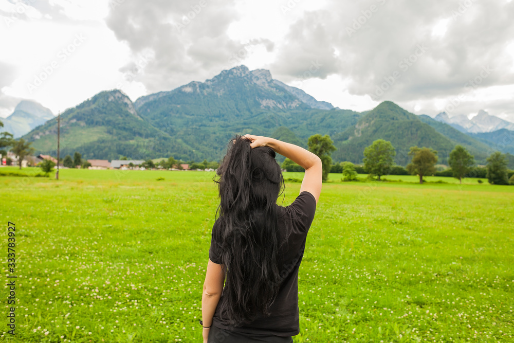 Happy young woman looks at the mountains