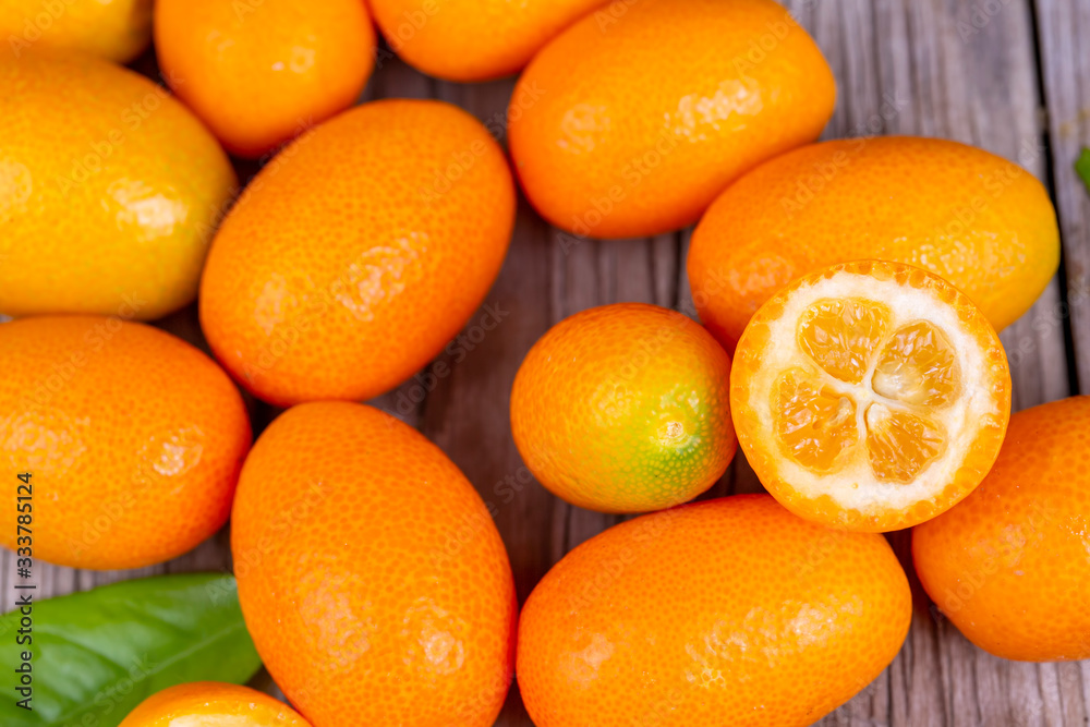 Top view of bunch of fresh kumquats in the organic food market. Some kumquats is cutted. Top view of bunch of fresh kumquats in the organic food market. Some kumquats is cutted.