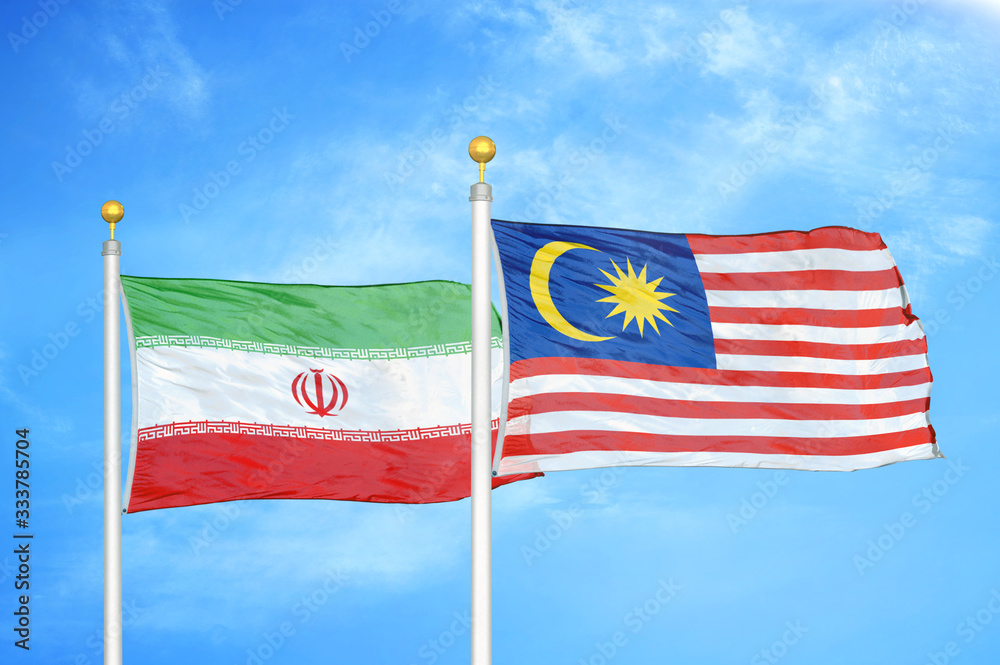 Fototapeta premium Iran and Malaysia two flags on flagpoles and blue cloudy sky