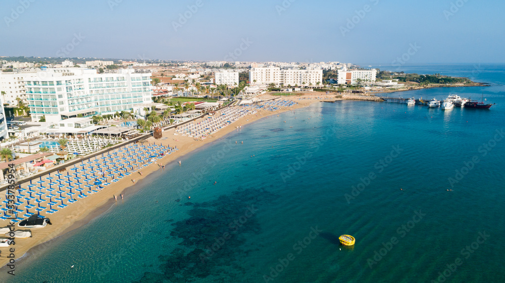 Aerial bird's eye view of Sunrise beach Fig tree, Protaras, Paralimni, Famagusta, Cyprus.The famous tourist attraction family bay with golden sand, boats, sunbeds, restaurants, water sports from above