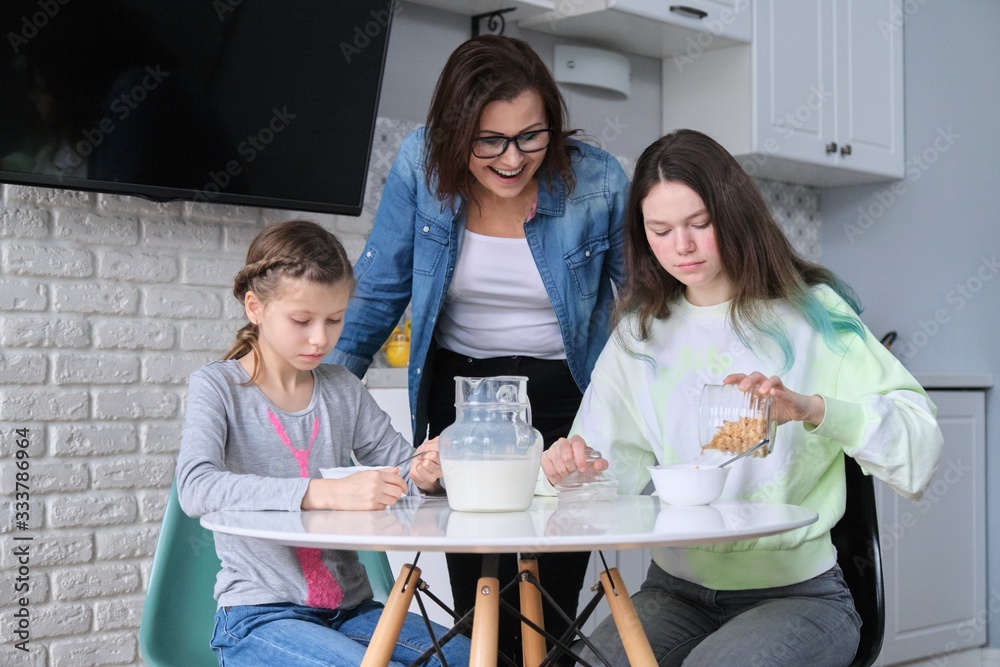 Children with mother eating at home in kitchen Children with mother eating at home in kitchen