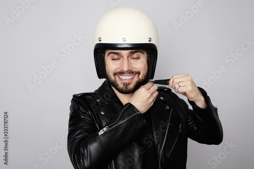 Close-up portrait of young happy biker man with white cafe-racer helmet. White background.