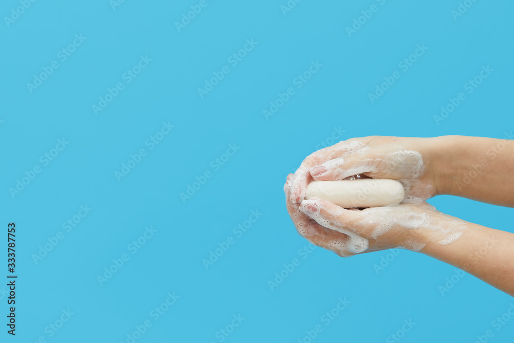 Hand hygiene concept. Female hands are holding antibacterial soap with foam on a blue background. Hand antiseptic during the coronovirus pandemic Hand hygiene concept. Female hands are holding antibacterial soap with foam on a blue background. Hand antiseptic during the coronovirus pandemic