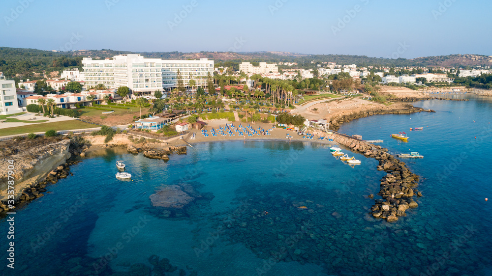 Aerial bird's eye view of Green bay in Protaras, Paralimni, Famagusta, Cyprus. Famous tourist attraction diving location rocky beach with boats, sunbeds, sea restaurants, water sports from above.