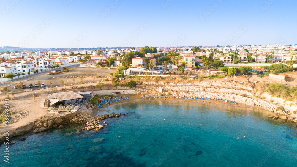 Aerial bird's eye view of Kapparis (fireman's) beach in Protaras, Paralimni, Famagusta, Cyprus. Tourist attraction golden sand Kaparis bay with boats, sunbeds, sea restaurants, water sports from above