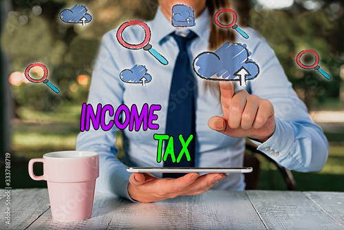 Conceptual hand writing showing Income Tax. Concept meaning Annual charge levied on both earned and unearned income photo