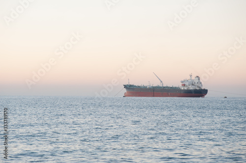 Cargo at sea. Cargo ship at sea on sunset background.